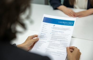 a woman is reading a resume at a table